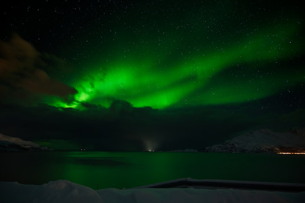 a bright green aurora over a body of water