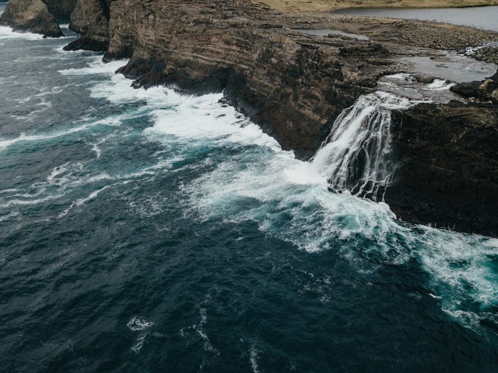 an aerial view of a waterfall in the ocean