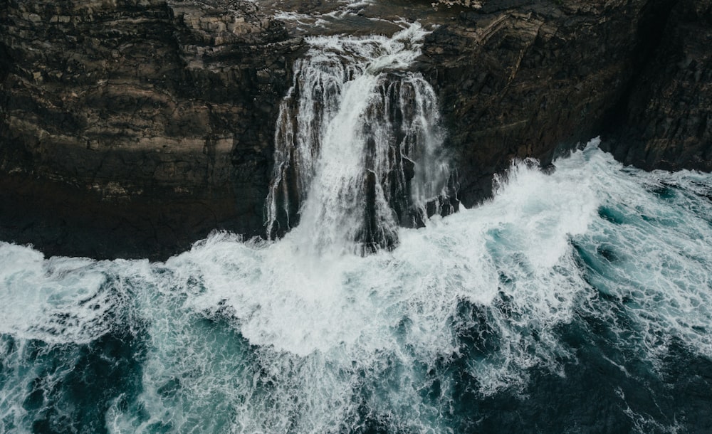 an aerial view of a waterfall in the ocean