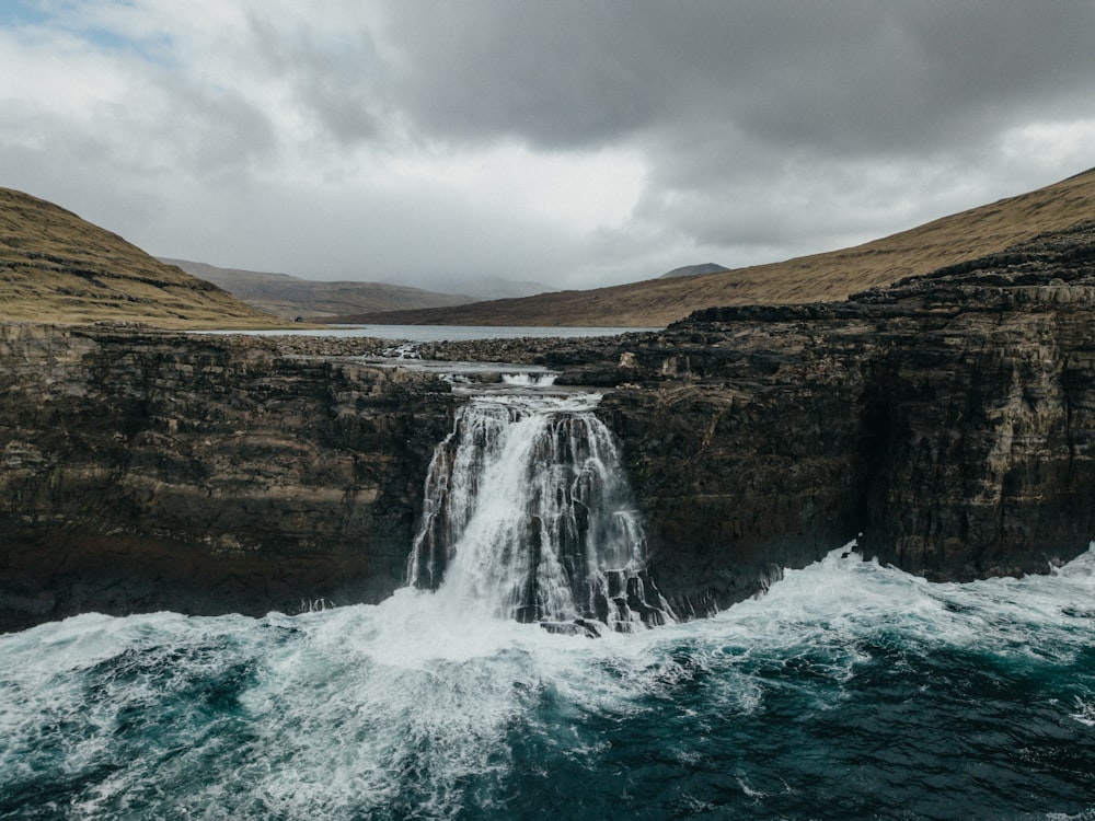 a waterfall in the middle of a body of water