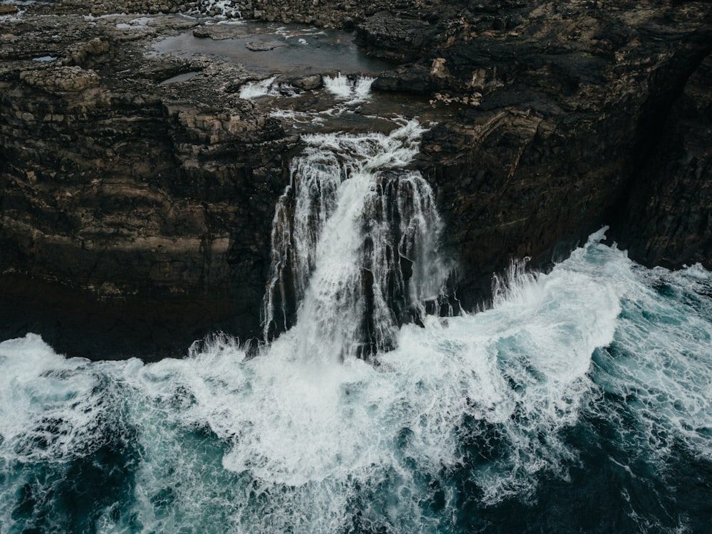 an aerial view of a waterfall in the ocean