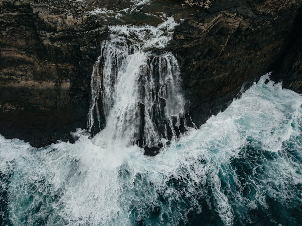 an aerial view of a waterfall in the ocean