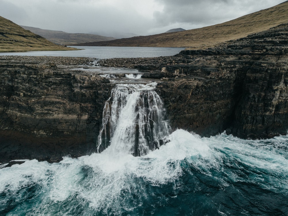 a waterfall with a body of water in front of it