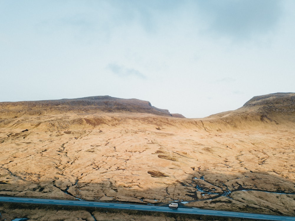 a car driving down a road in the desert