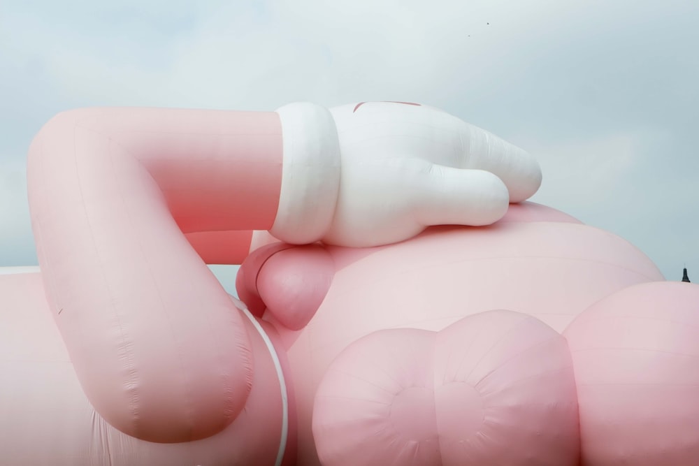 um grande objeto inflável rosa com um tubo branco saindo dele