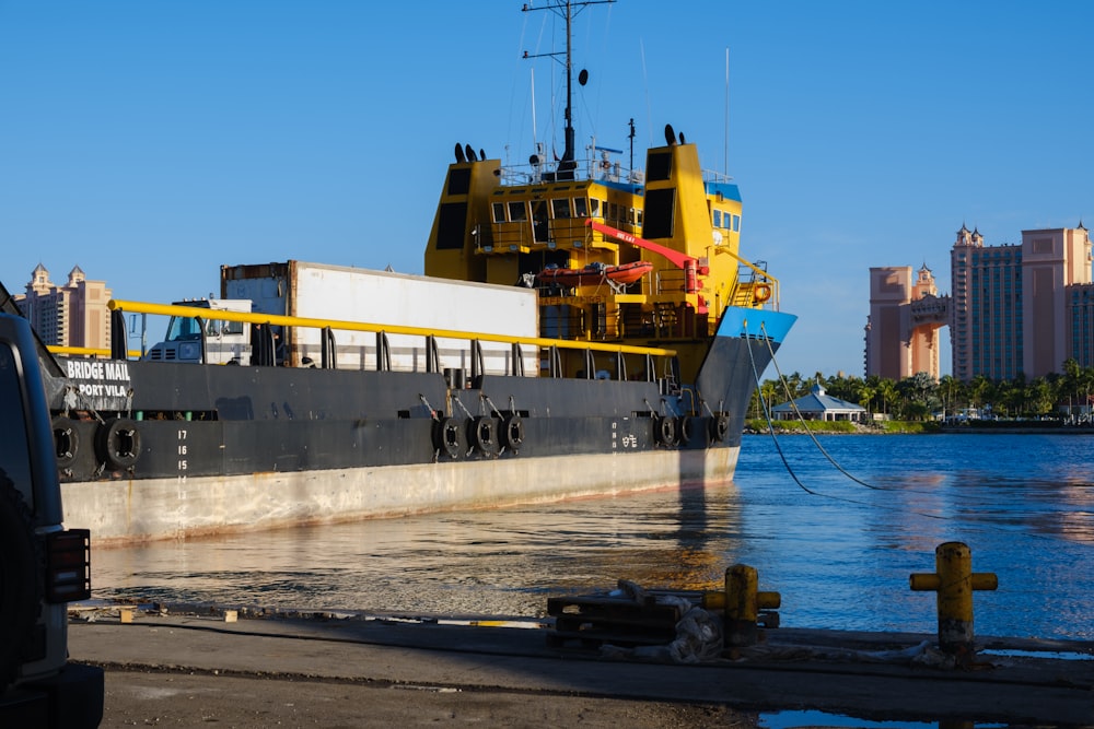 a yellow and black boat docked in the water