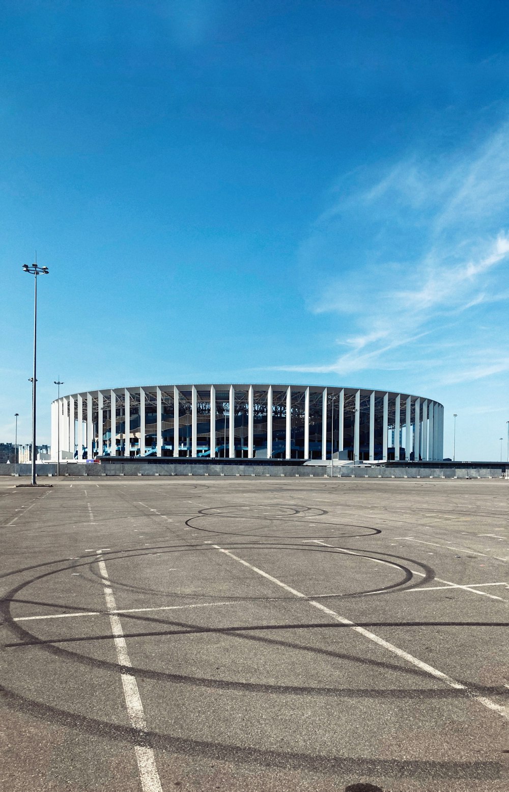 an empty parking lot with a large building in the background