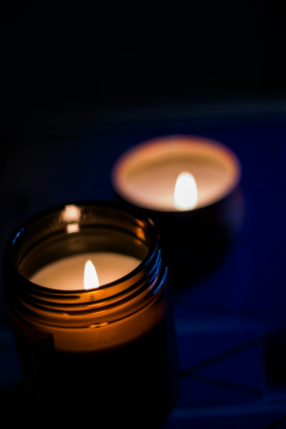 two lit candles sitting on top of a table