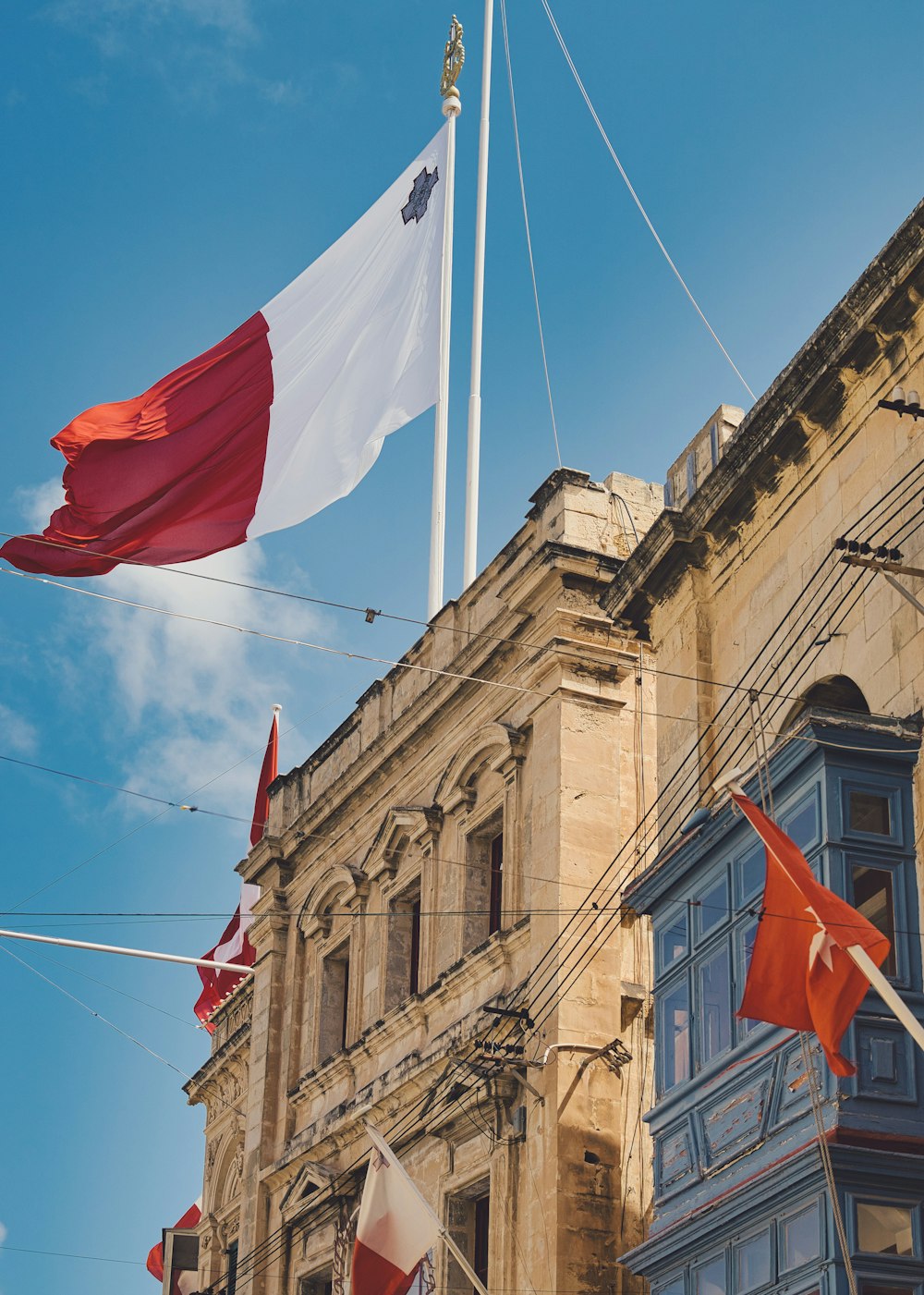 a group of flags flying in front of a building