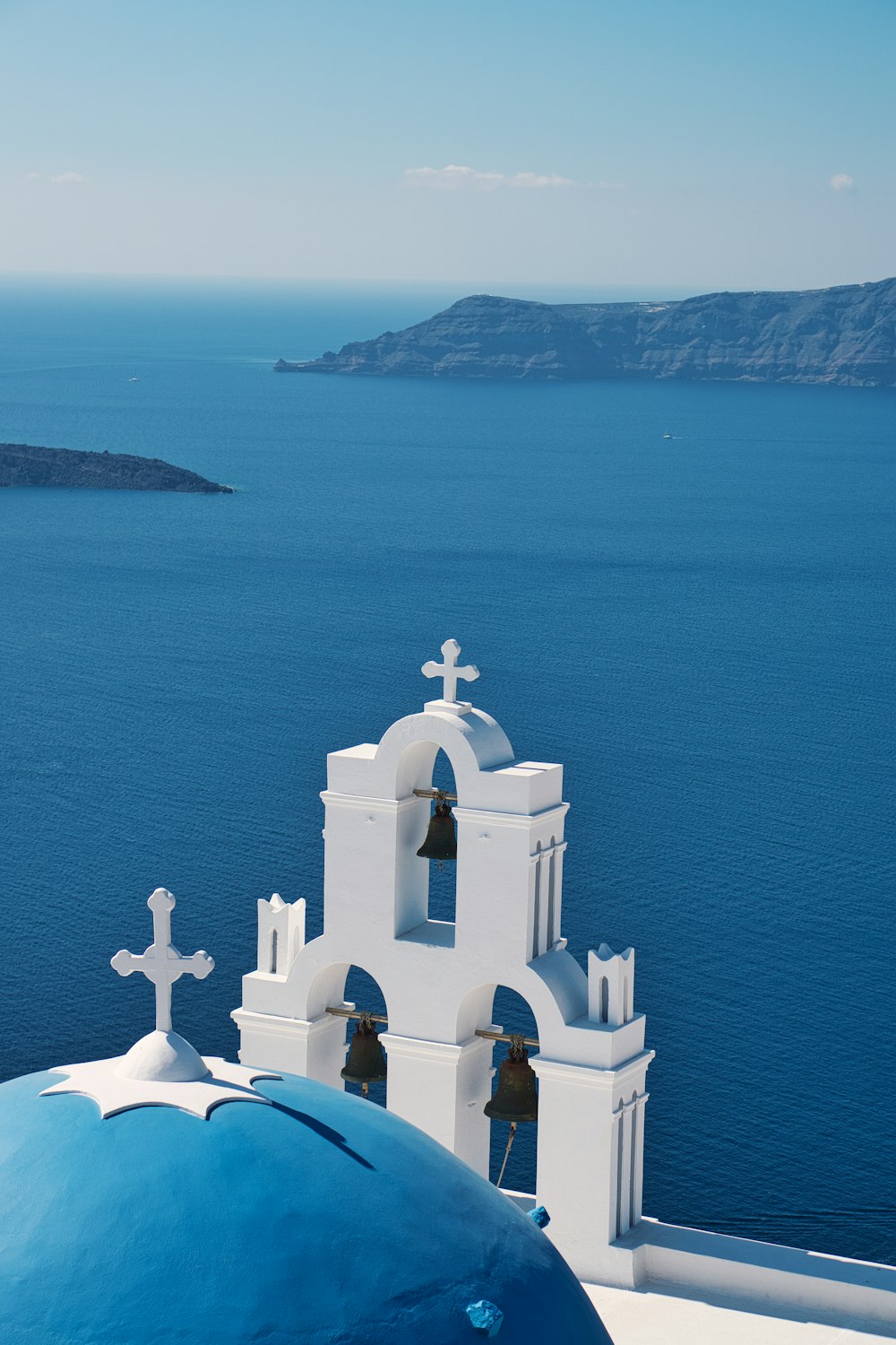 a church with a bell tower next to a body of water