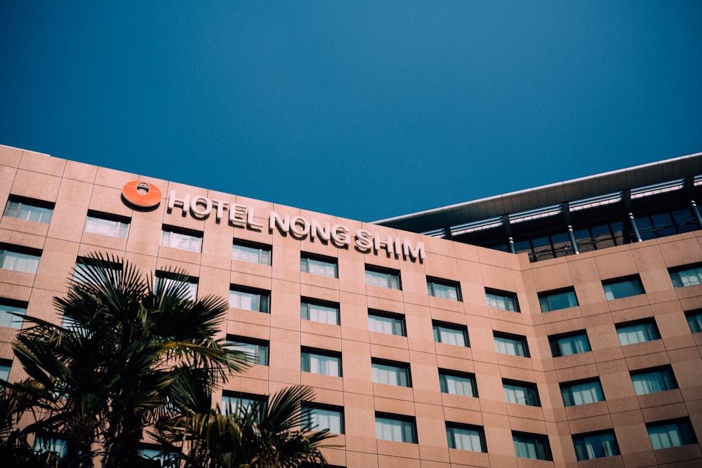 a hotel building with palm trees in front of it