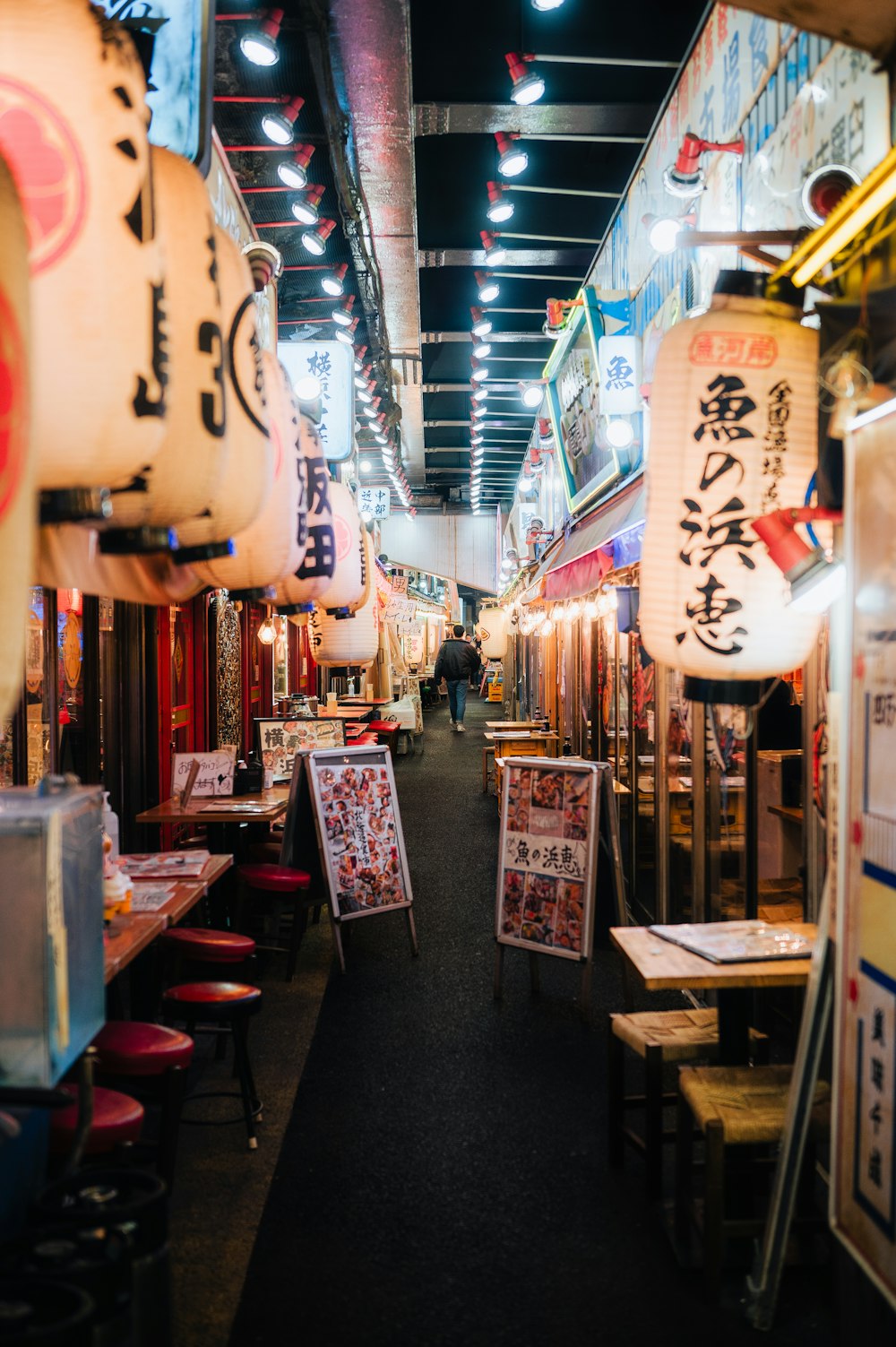 a narrow alley way with tables and chairs