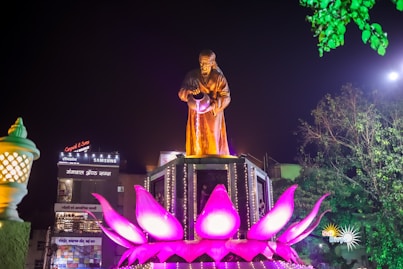 a statue of a man standing on top of a flower