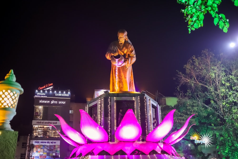 a statue of a man standing on top of a flower