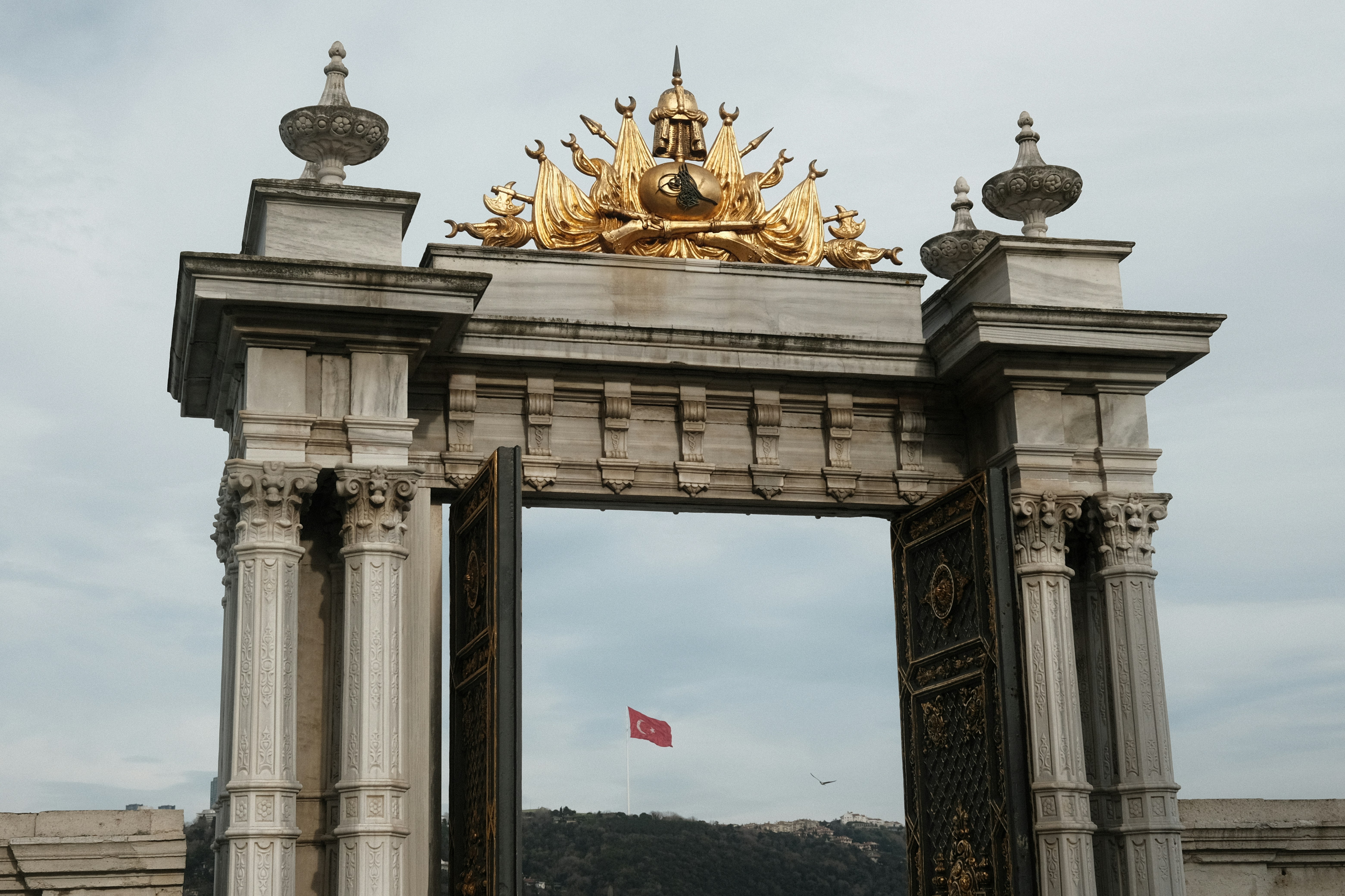 a golden statue on top of a stone arch