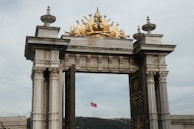 a golden statue on top of a stone arch
