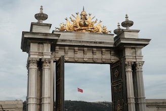 a golden statue on top of a stone arch