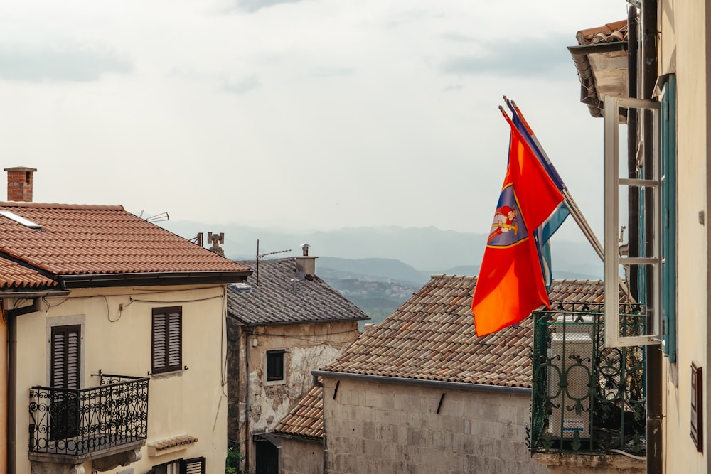 a red and blue flag flying from a balcony