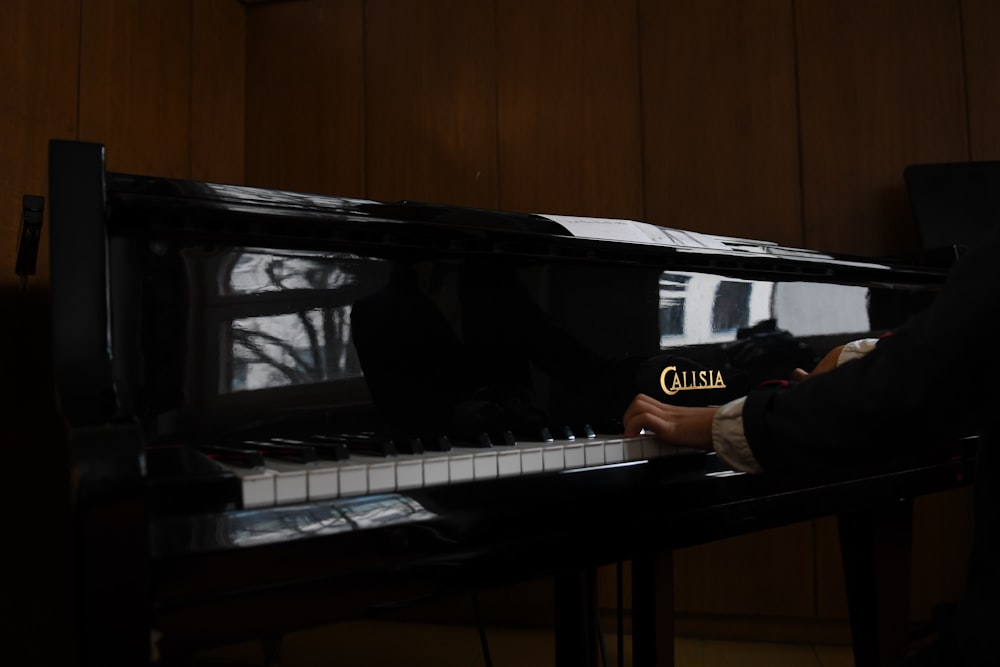 uma pessoa tocando piano em um quarto escuro