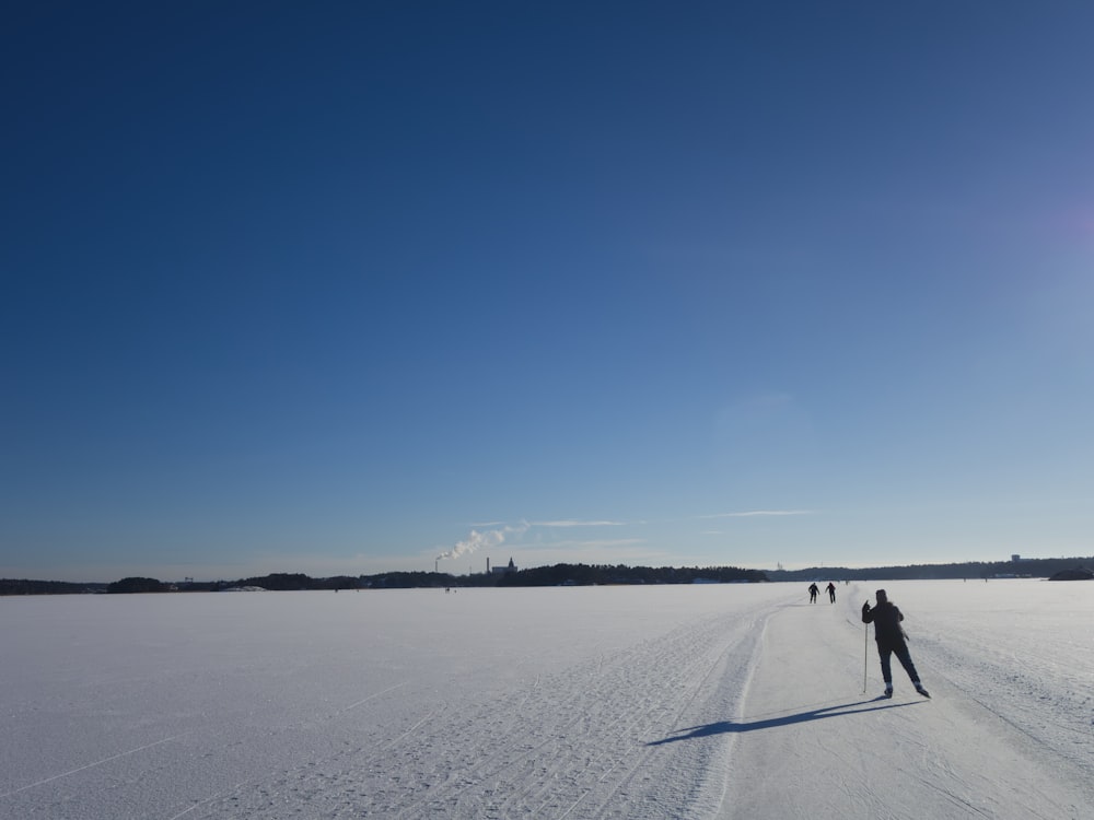 a group of people walking across a snow covered field