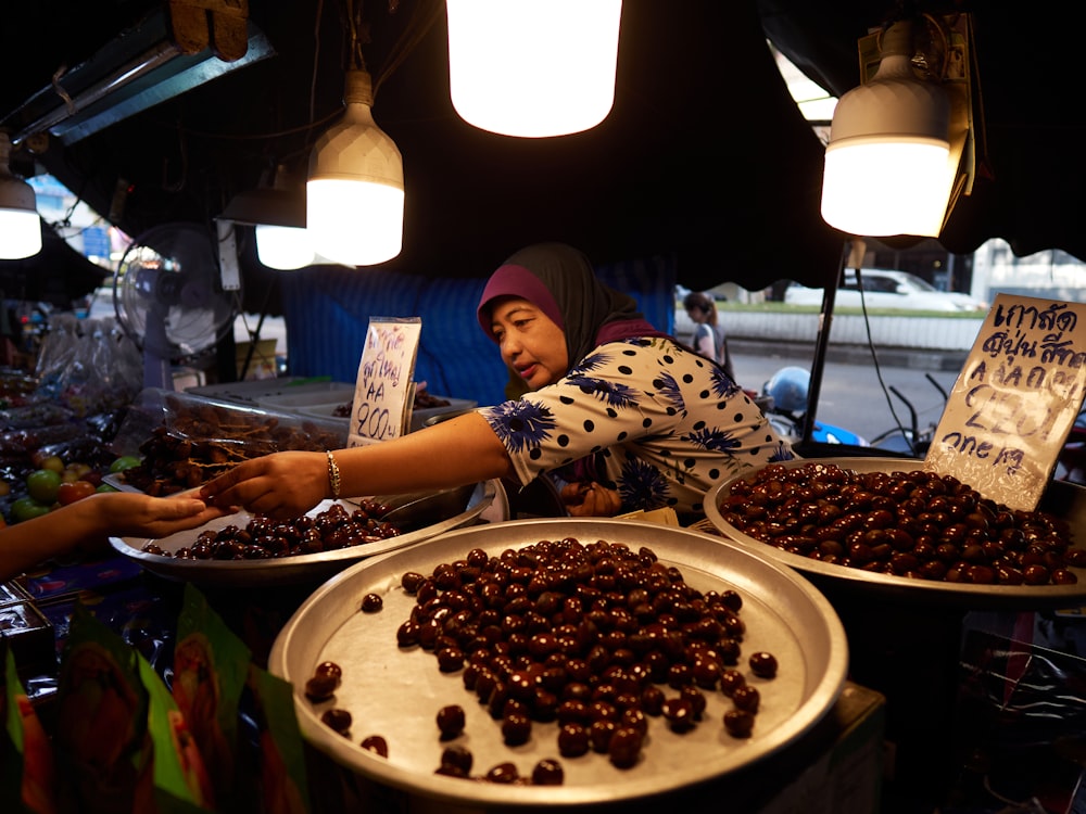 a woman standing in front of a table filled with lots of food