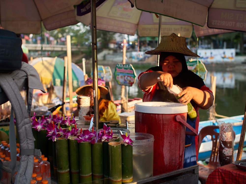 a woman in a straw hat is making a drink