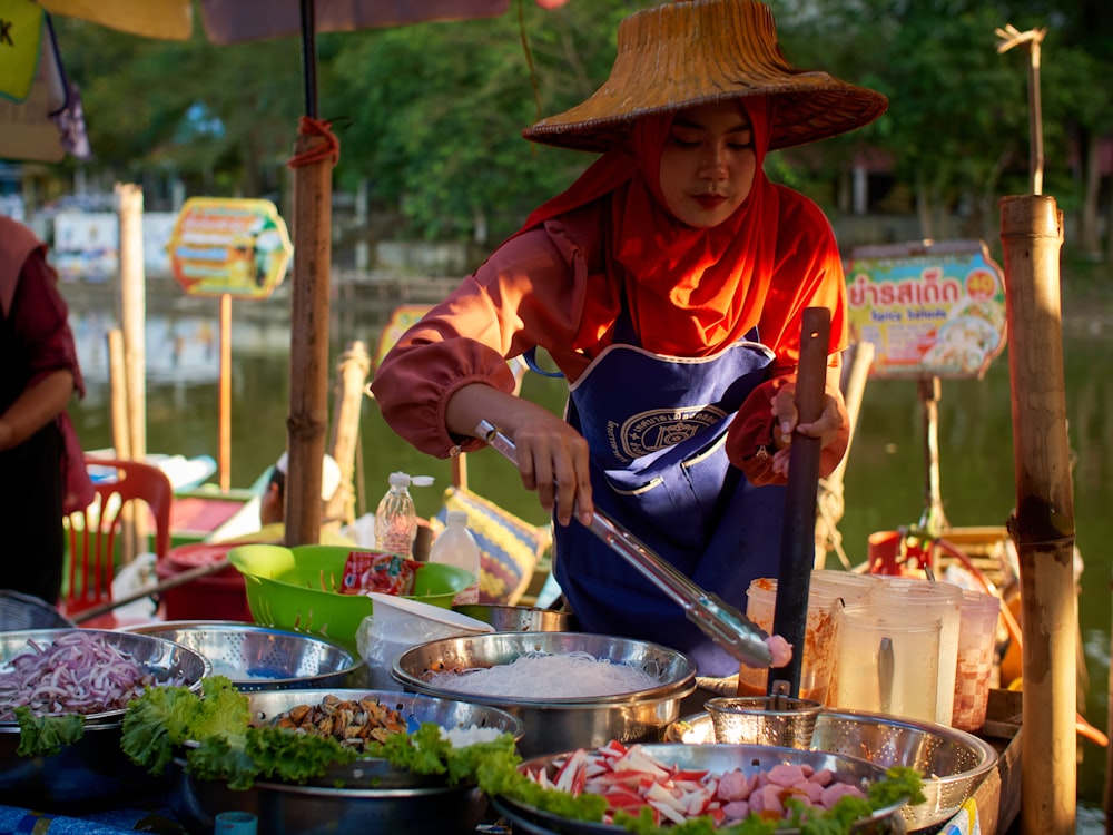 a woman in a straw hat preparing food on a table