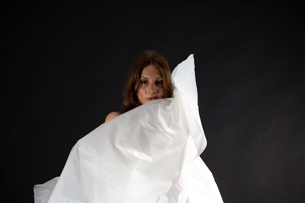 a woman holding a white sheet of paper