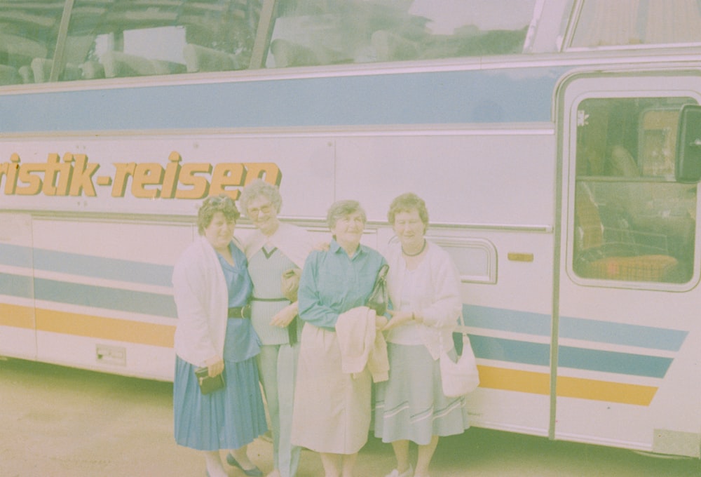 a group of people standing in front of a bus