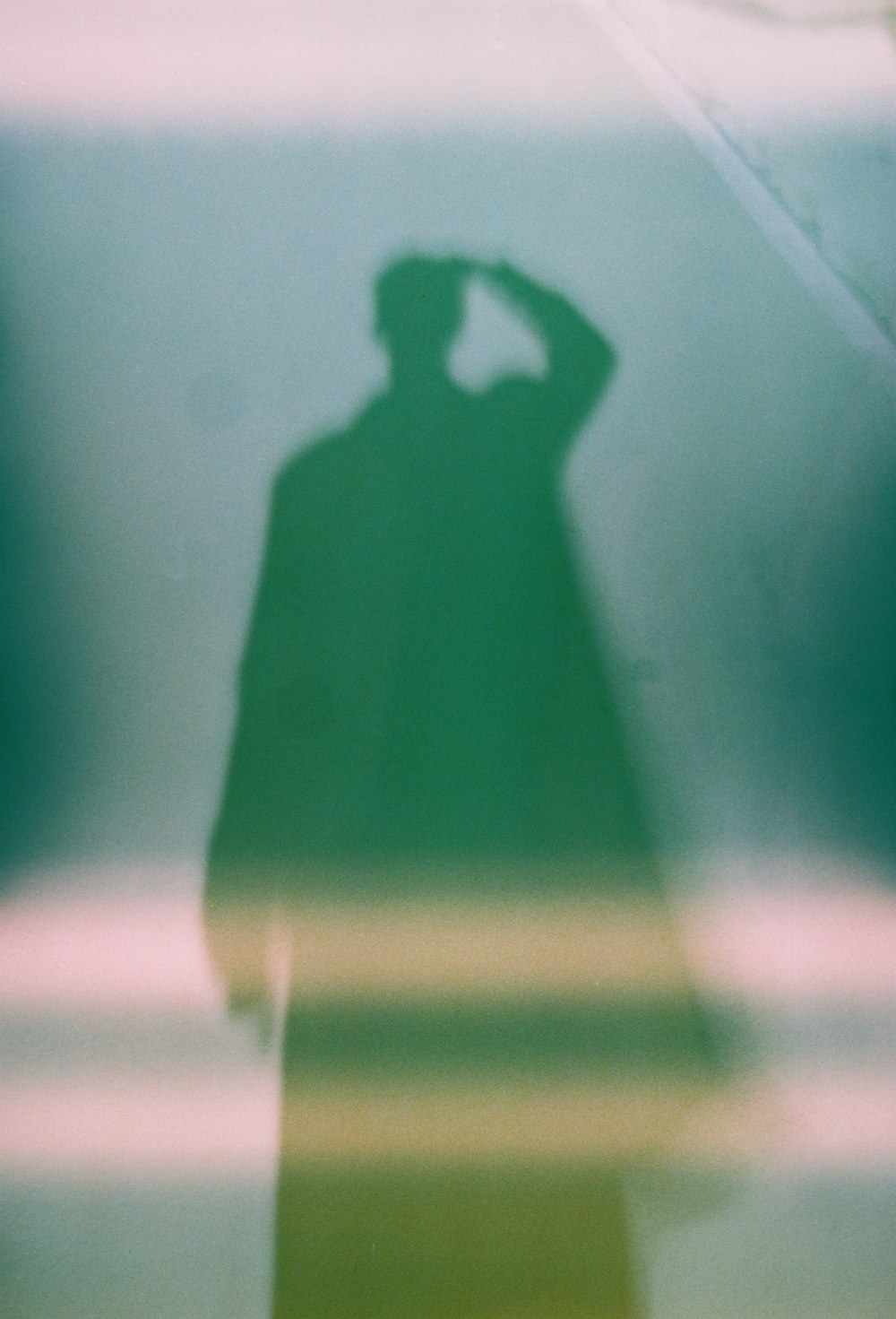 a shadow of a man standing next to a wall