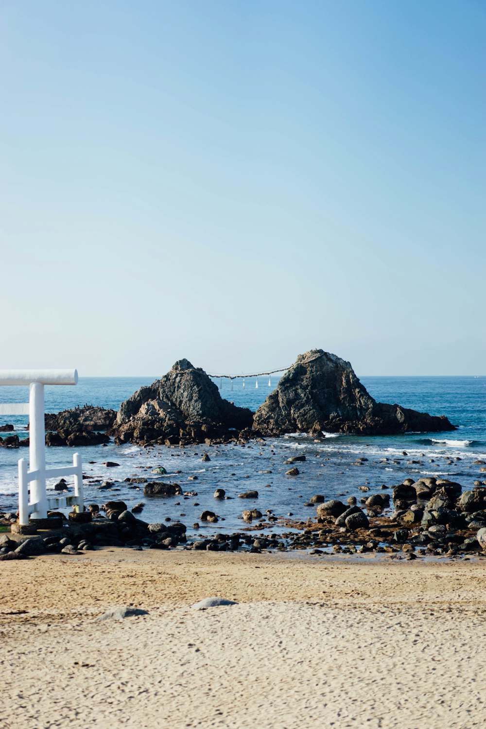 a white bench sitting on top of a sandy beach