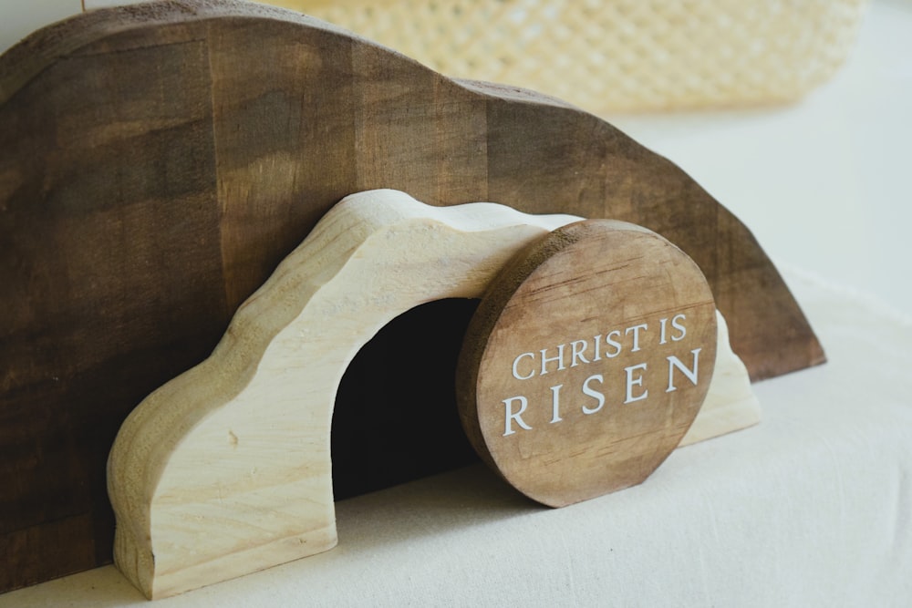 a wooden sculpture of a bear with the words christ is risen on it
