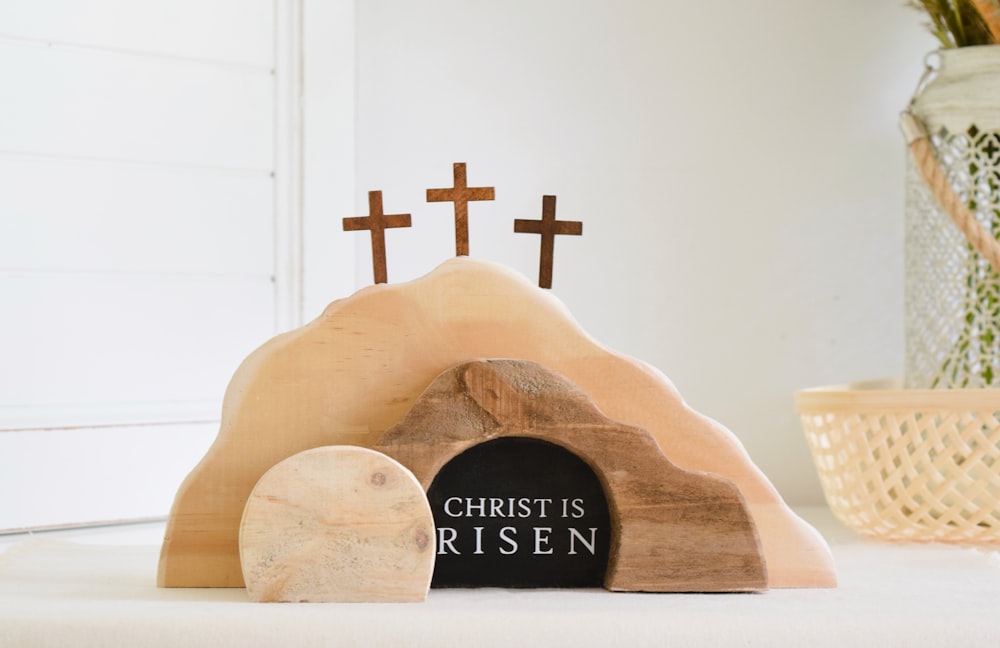 a wooden statue of a rock with a cross on it