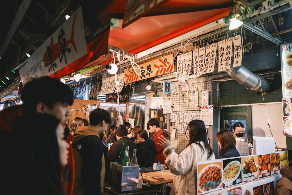 a group of people standing around a food stand