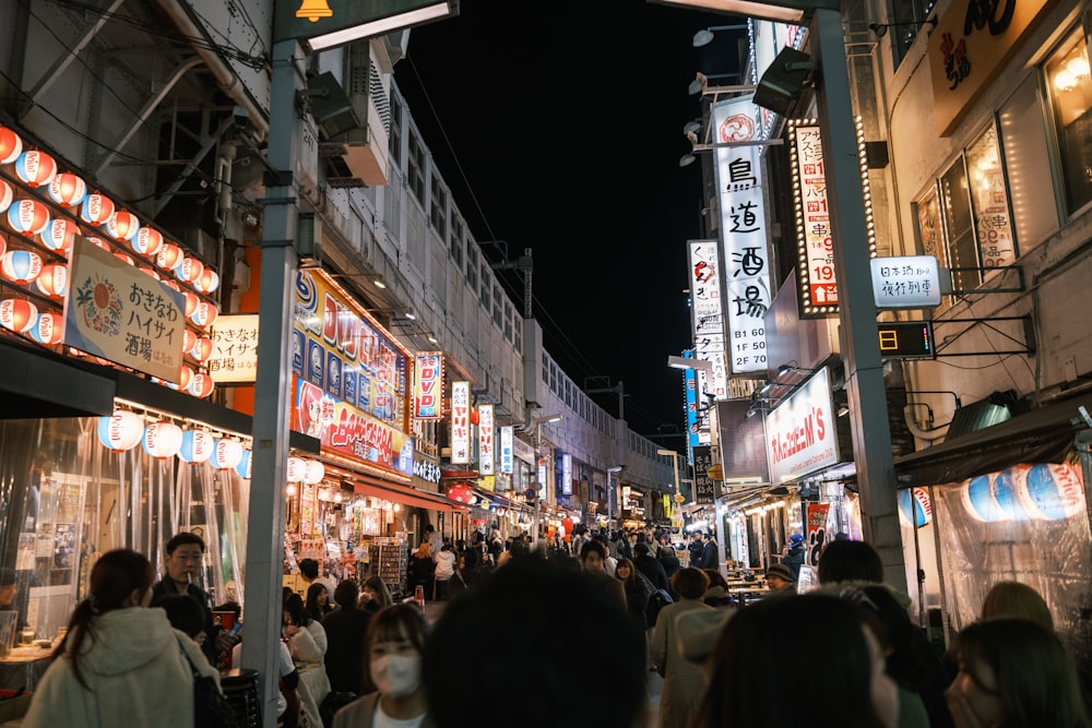 a group of people walking down a street at night