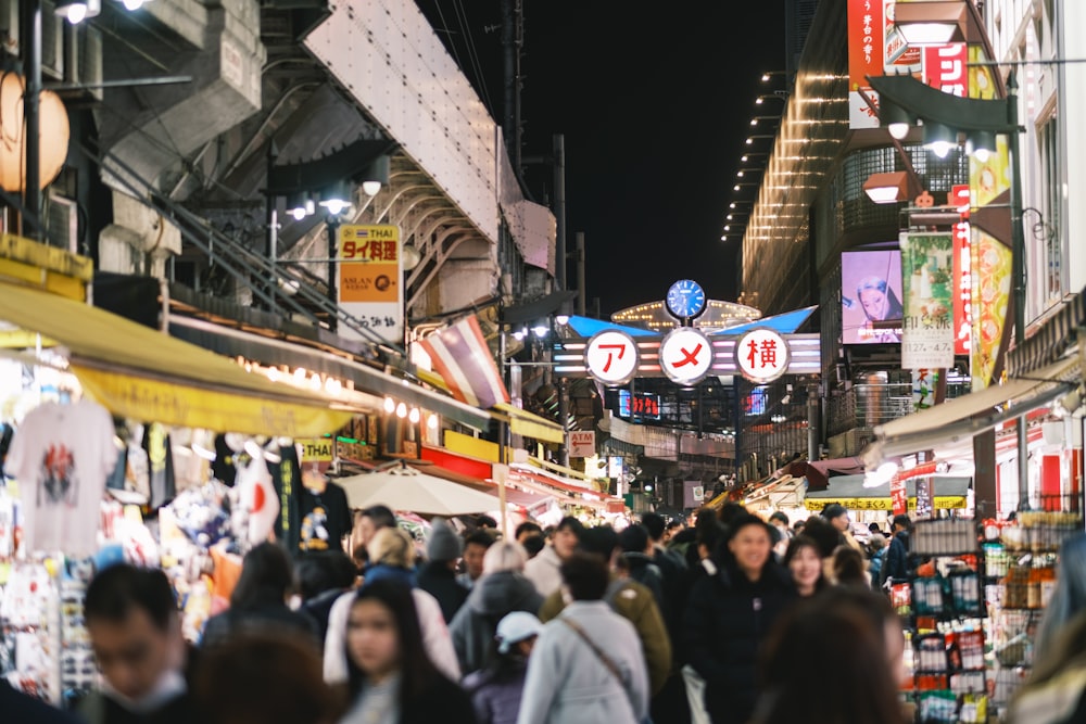 many people are walking through a crowded market