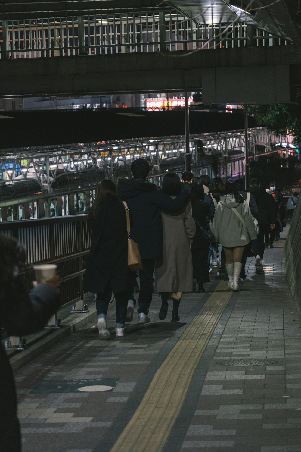 a group of people walking down a subway platform