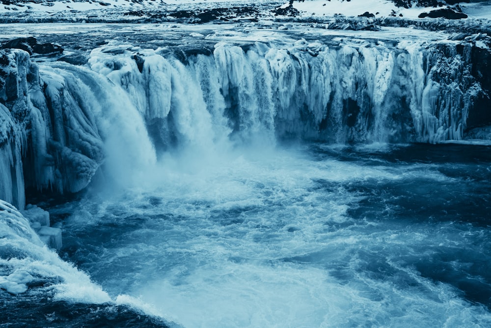 a large waterfall that is surrounded by ice