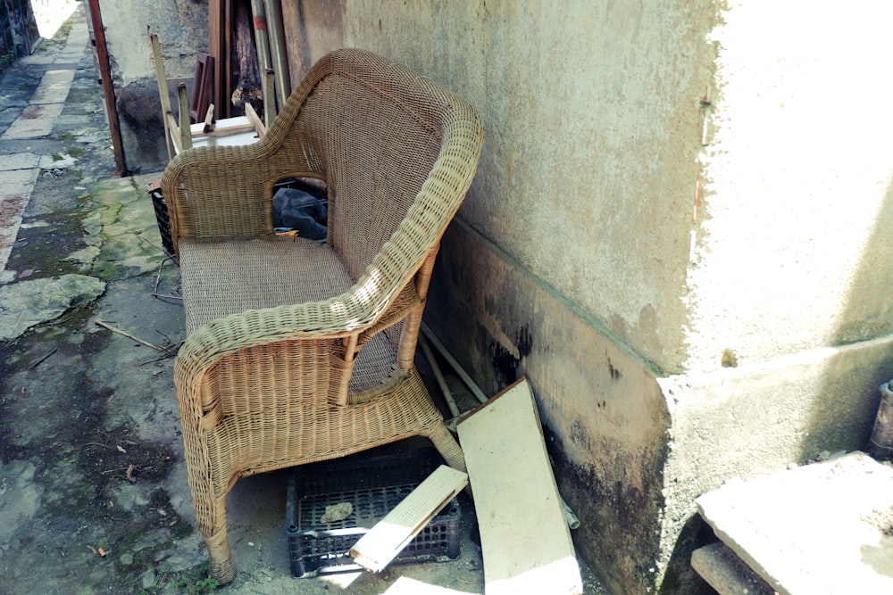 a wicker chair sitting on the side of a building