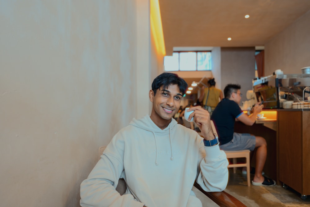 a man sitting at a table with a cup of coffee