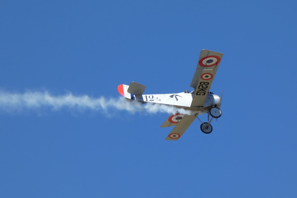 a small airplane flying through a blue sky