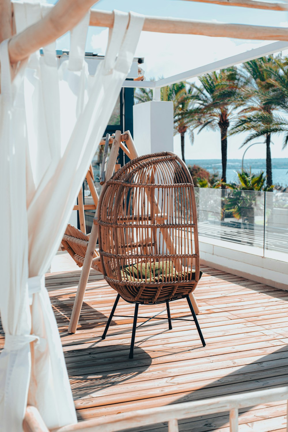 a wicker chair sitting on a wooden deck