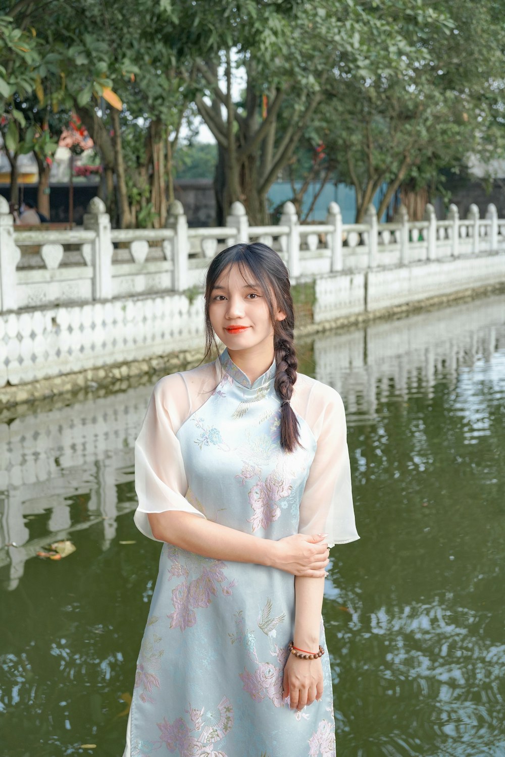 a woman standing in front of a body of water