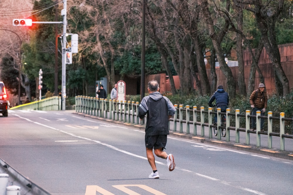 a man running across a street next to a traffic light