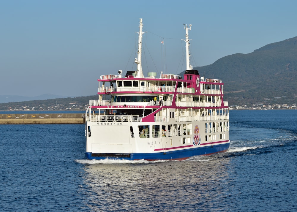 a large white and blue boat traveling across a body of water