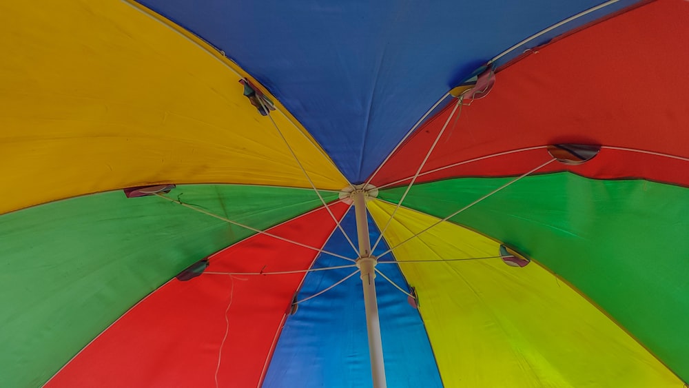 a multicolored umbrella is open on a sunny day