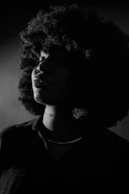 a black and white photo of a woman with curly hair