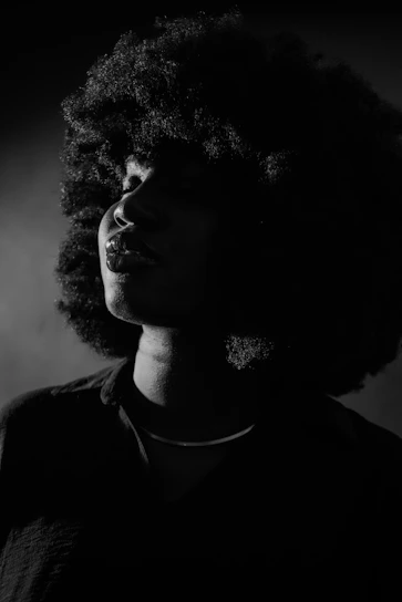 a black and white photo of a woman with curly hair