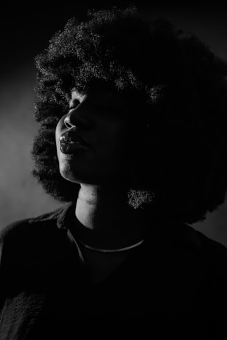a black and white photo of a woman with curly hair