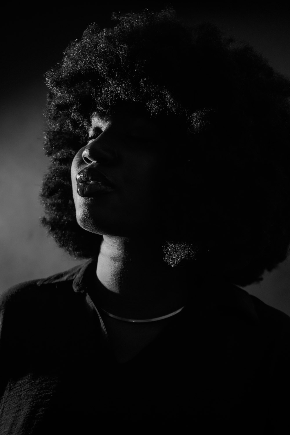 a black and white photo of a woman with curly hair